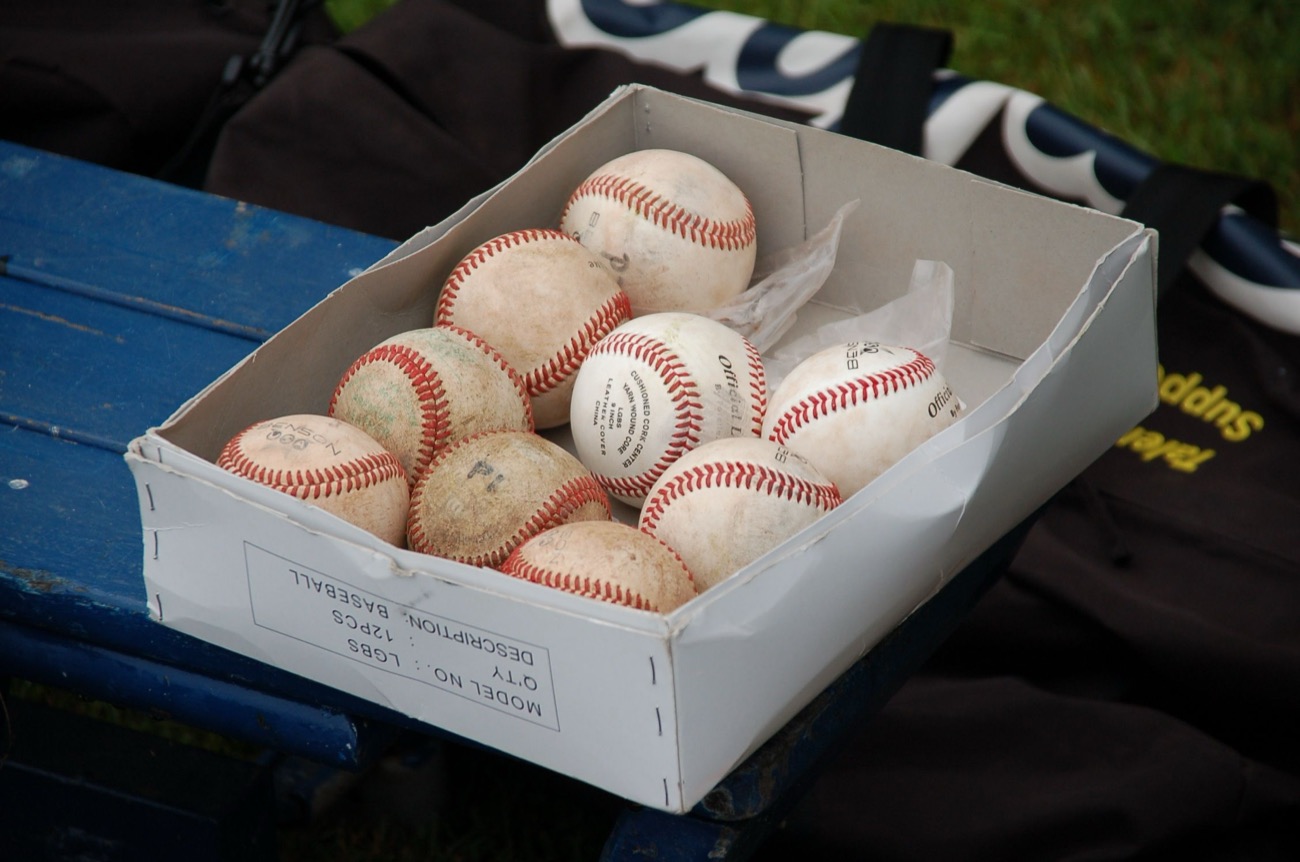 College coaches watching a baseball game from behind the backstop