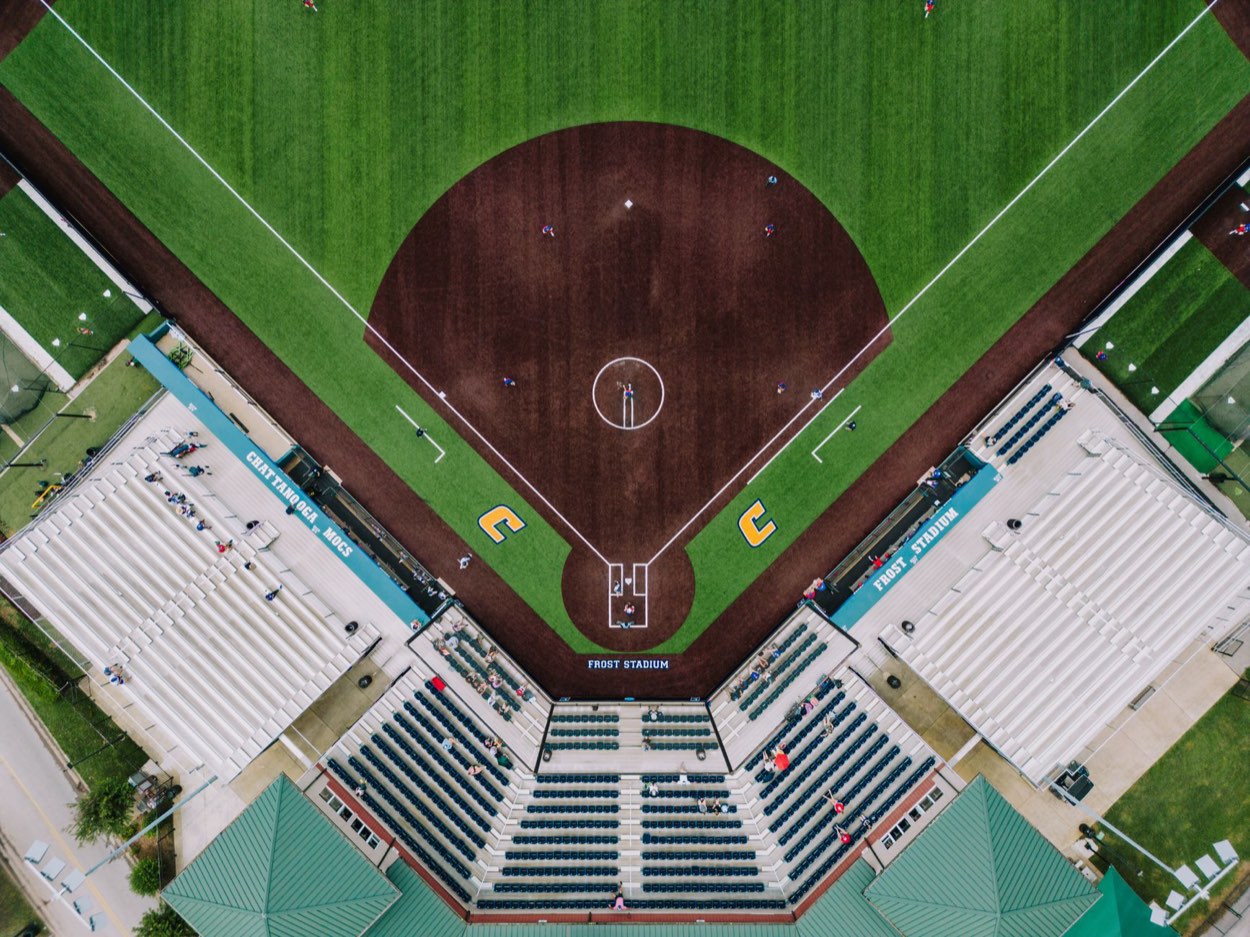 Scout timing a pitch with a radar gun behind the backstop