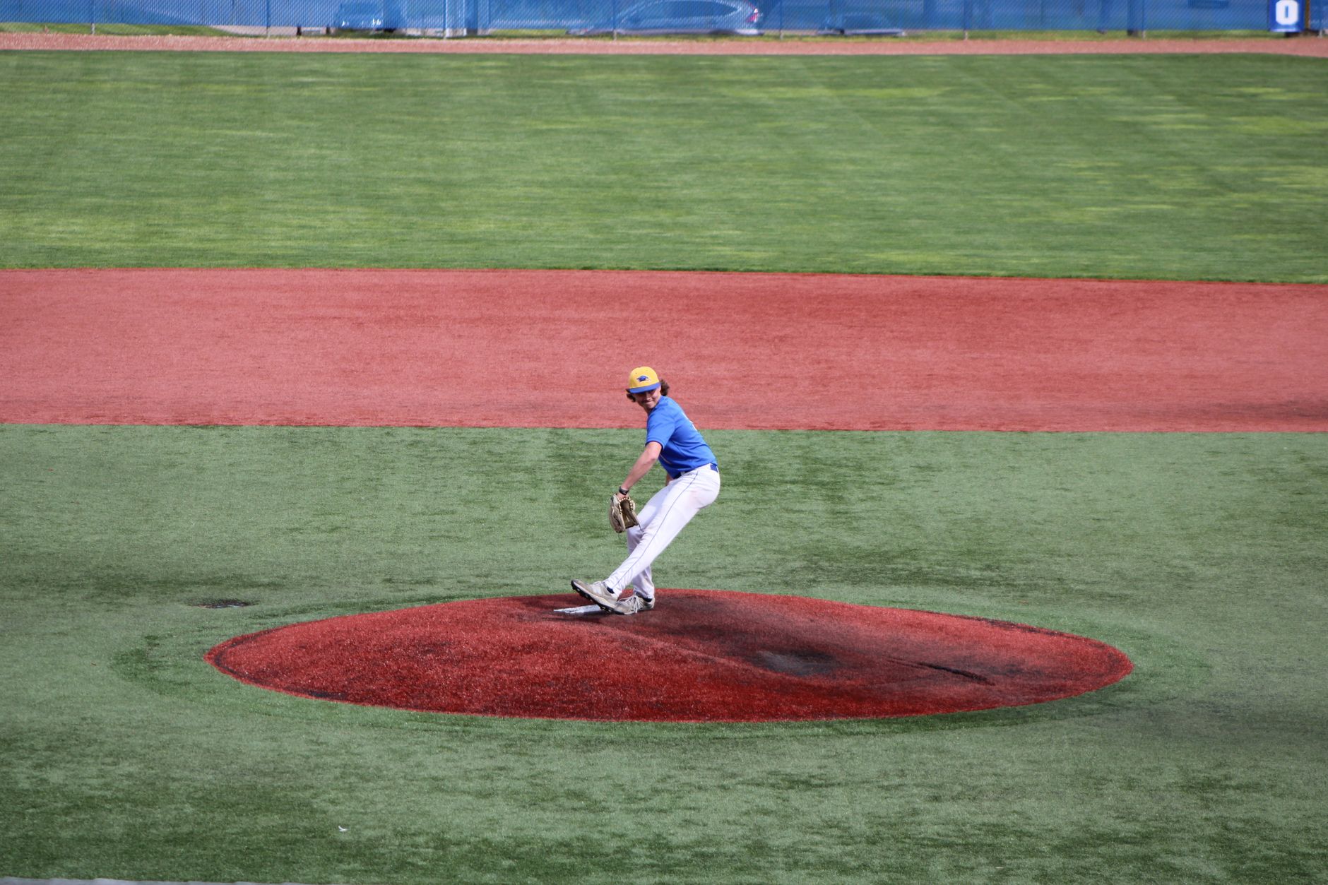Youth pitcher on the mound mid-windup